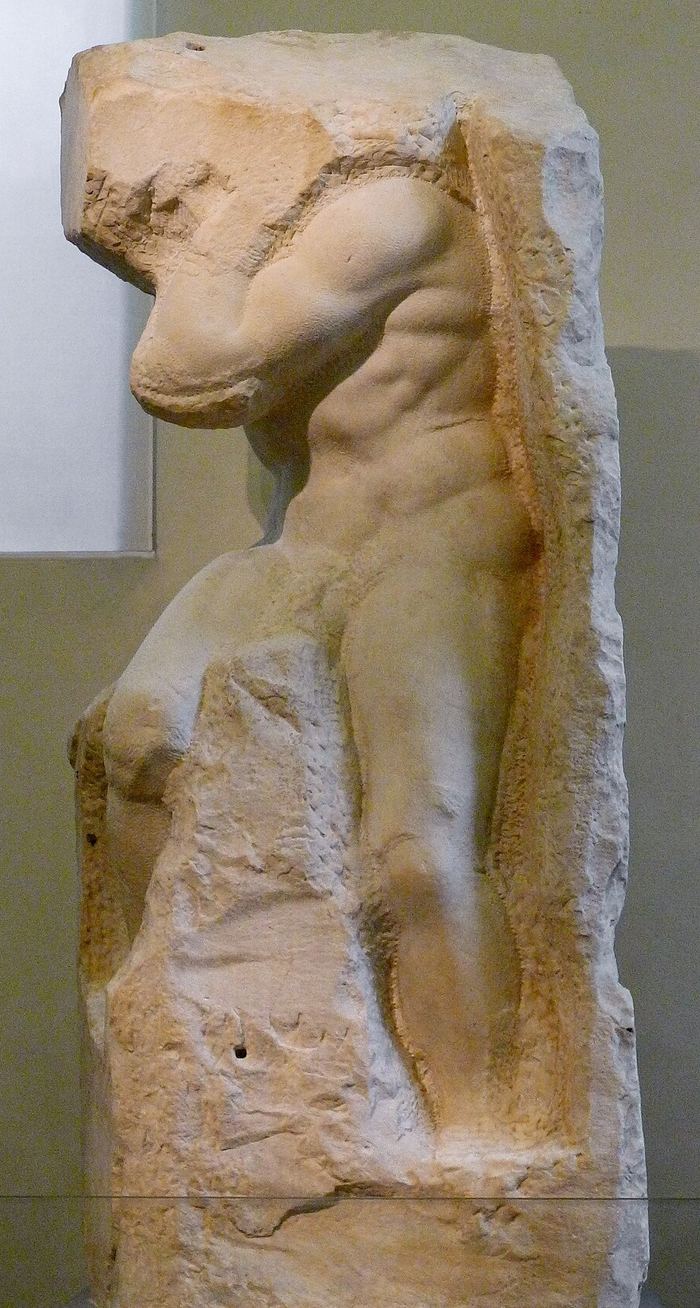 Un torso emergiendo de un bloque de mármol sin desbastar, inacabado — Prigione «Atlante» de Michelangelo. Foto de Jörg Bittner Unna, CC BY-SA 3.0.